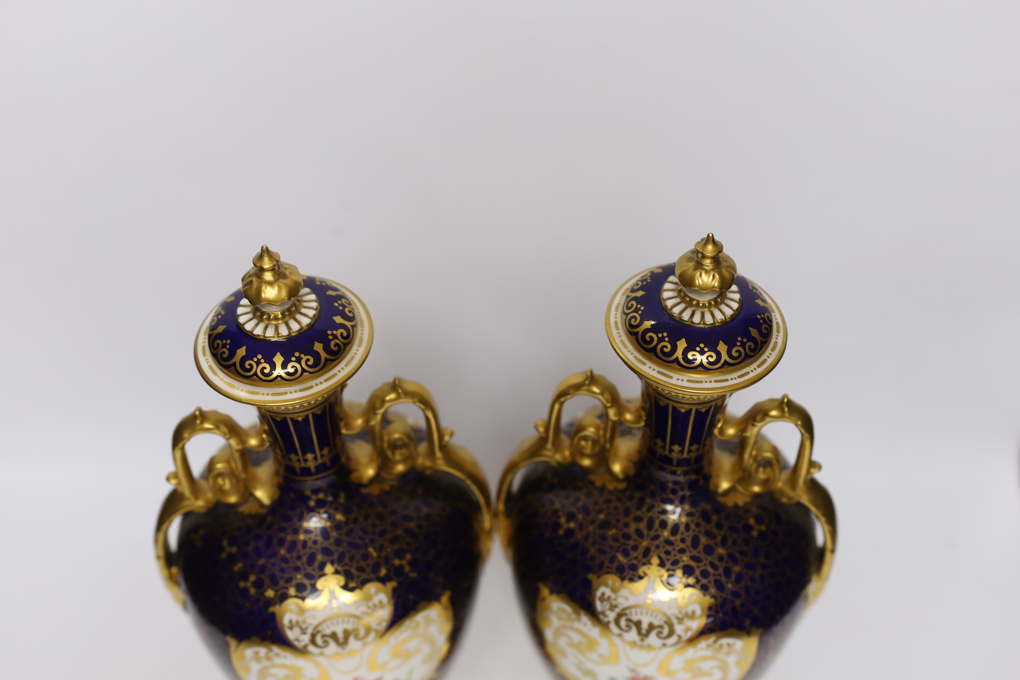 A pair of Royal Crown Derby porcelain urns and covers together with a smaller example and an Imari style jar and cover, 36cm high